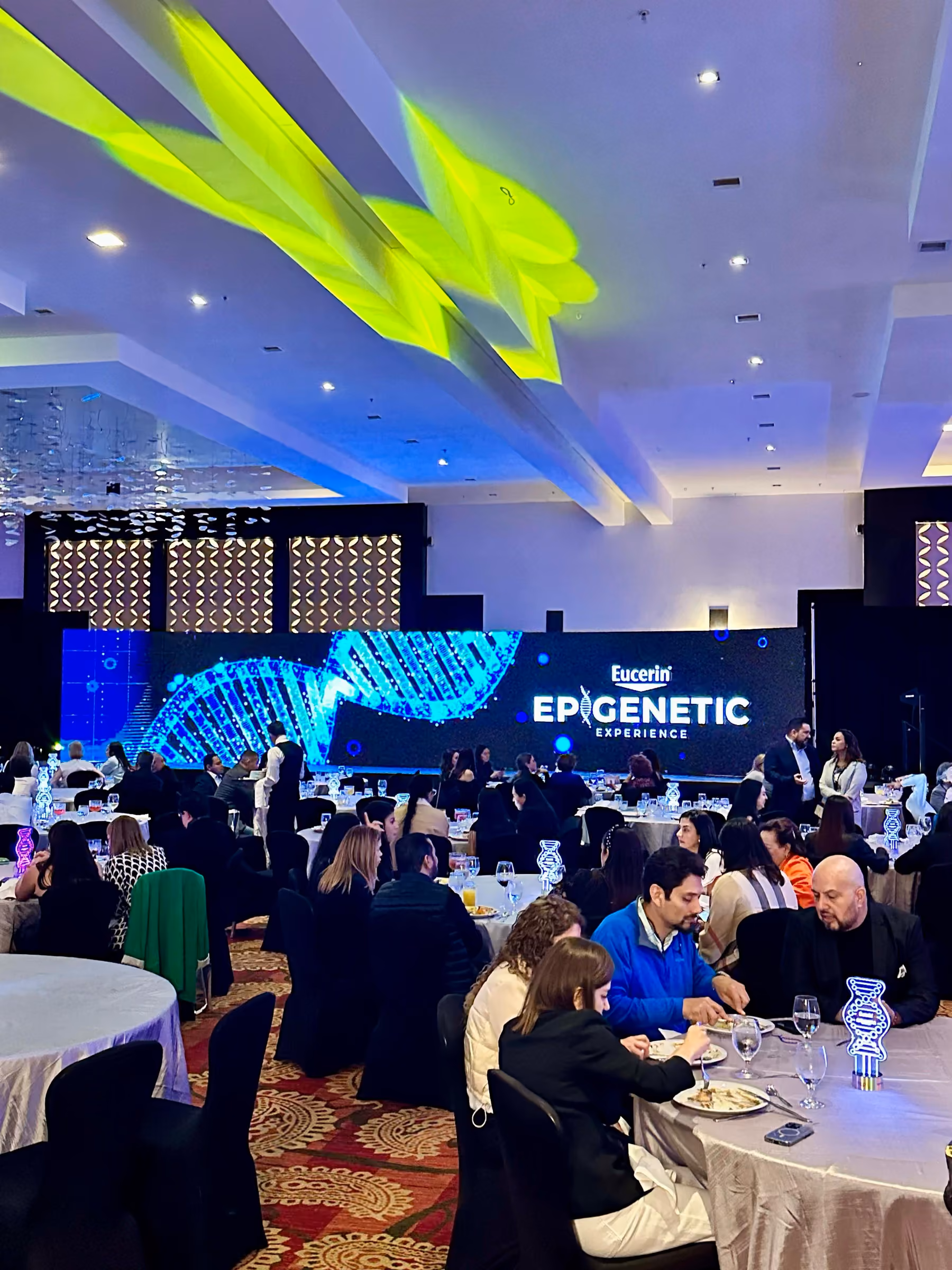 Cena de gala con pantalla LED y luces proyectadas en el techo